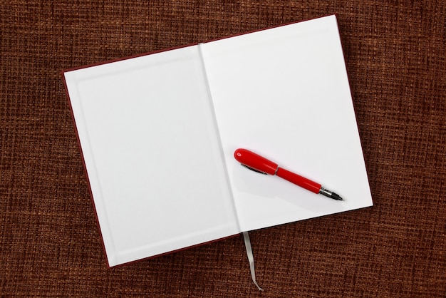 Open notepad and red pen closeup