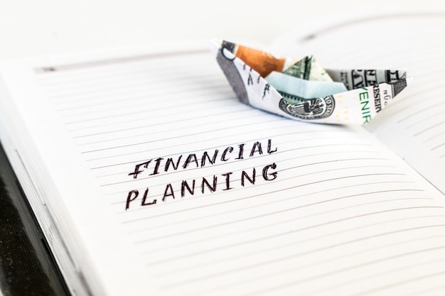 Open notepad with the handwriting text FINANCIAL PLANNING 