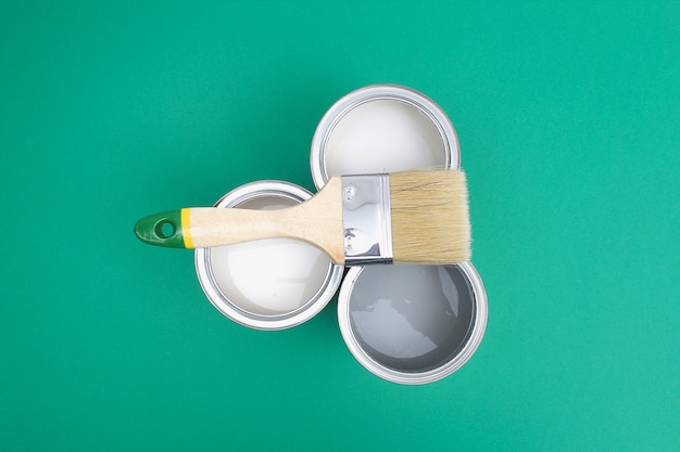 Open paint enamel cans on color palette samples.