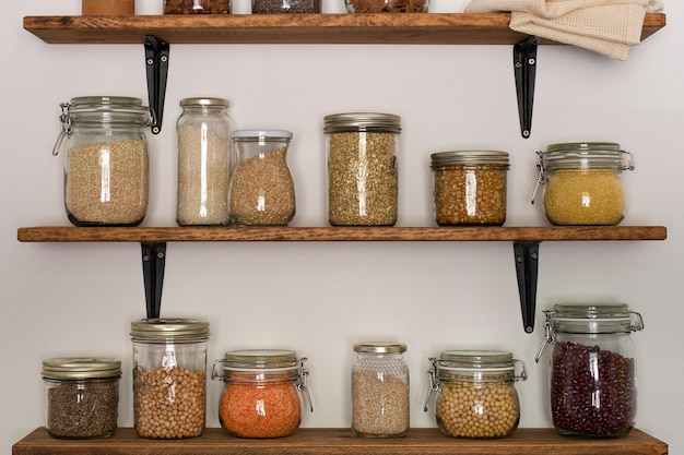 Open pantry houten planken met glazen voorraadbakken gevuld met granen en peulvruchtenBiologisch voedsel