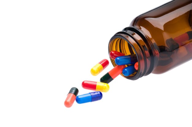 Open pharmaceutical bottle which spills colored capsules