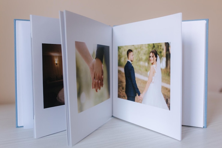 白い木製のテーブルに美しいカップルの写真を wrdding で開いた写真集