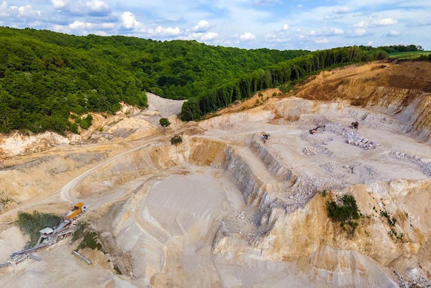 Estrazione a cielo aperto di materiali lapidei da costruzione con escavatori e autocarri con cassone ribaltabile