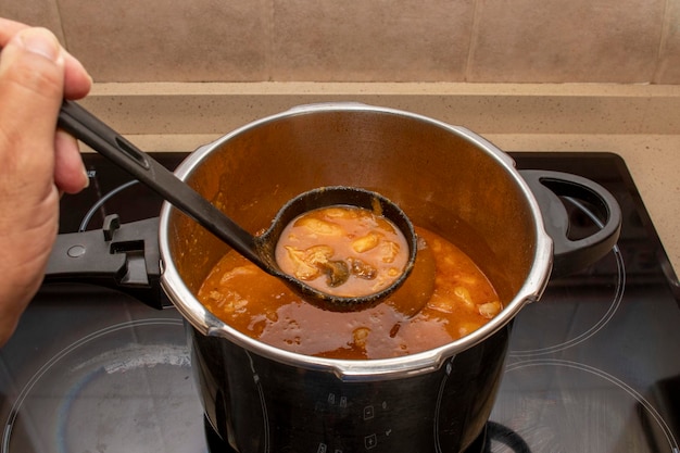 An open pressure cooker with a bean stew viewed from above Typical Asturian Fabada stew