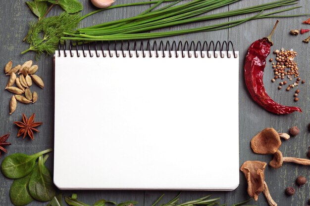 Foto open receptenboek met verse kruiden en specerijen op houten ondergrond