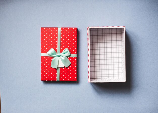 Open red gift with bow on blue background