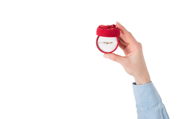 Open red jewelry box with ring in female hand. 