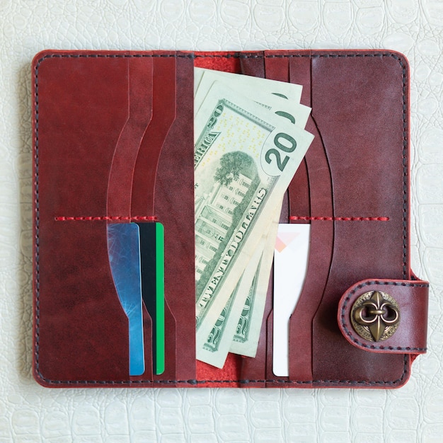 Open red leather clutch with money and credit cards