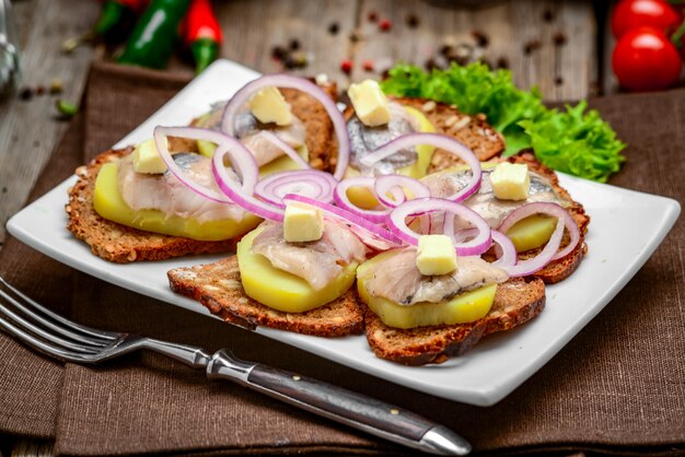 Open sandwich met haring, ui, aardappel en boter