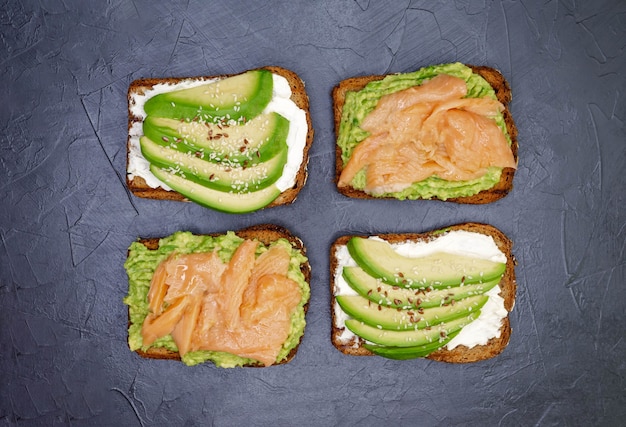 Foto panino aperto con pane di segale scuro, avocado e salmone.