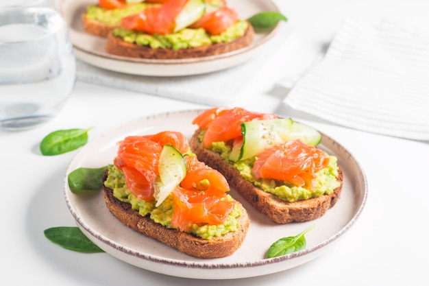 Open sandwich with smoked and salted salmon for healthy breakfast. Trout and avocado on bruschetta t