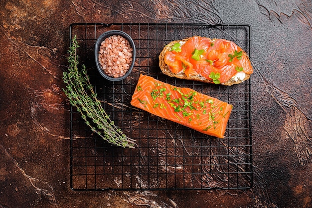 Open sandwichtoast met koude gerookte zalmfiletkruiden Donkere achtergrond Bovenaanzicht