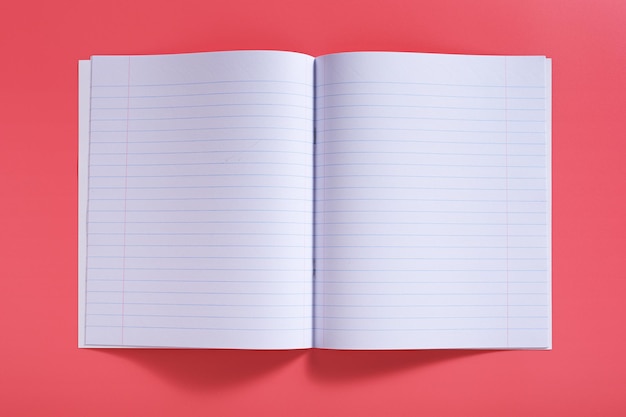 Open school notebook on pink background top view