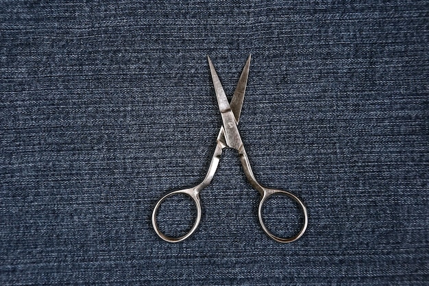 Open scissors lying on denim