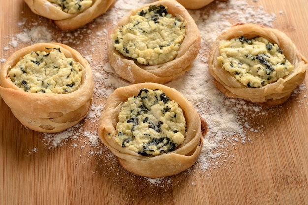 Open sfiha filled with ricotta cheese and spinach on a wood