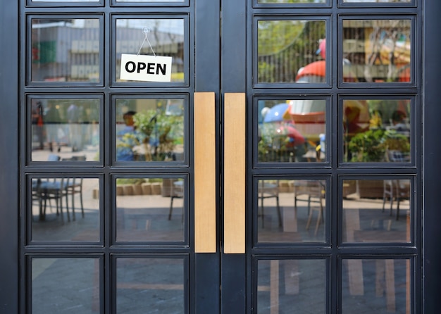 Open sign board hanging on door of cafe