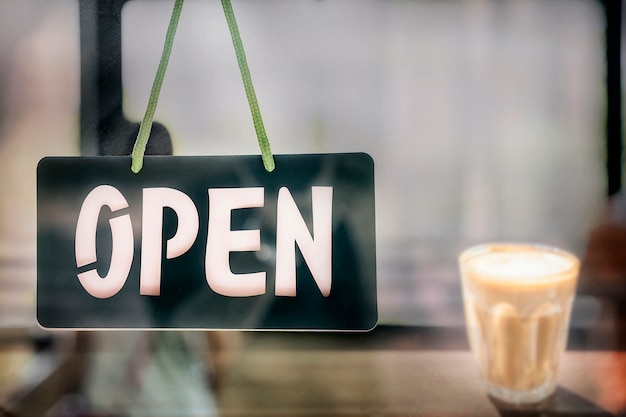 Photo open sign board hanging on the door of coffee shop.