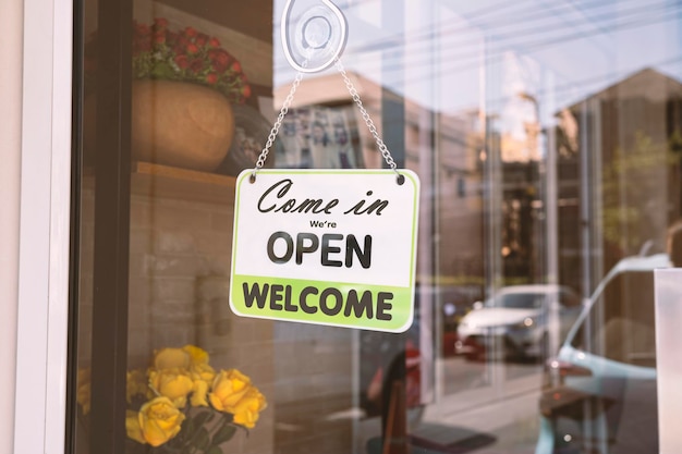 Photo open sign broad through the glass of door in cafe