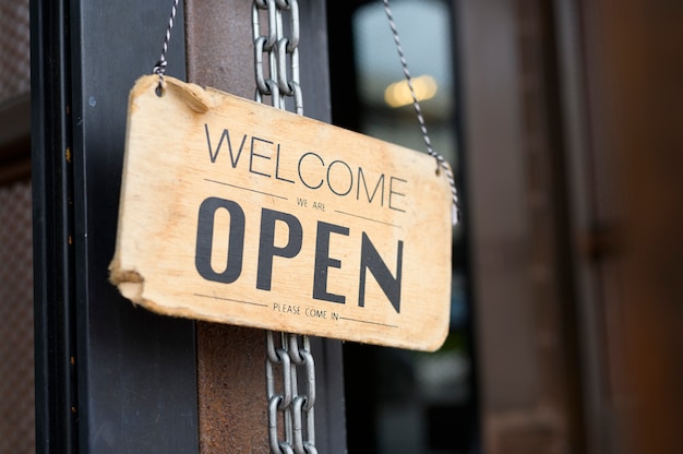 Open sign in coffee shop door , business reopen After Covid-19 outbreak concept .