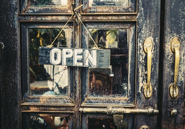 Foto un cartello aperto appeso alla porta d'epoca