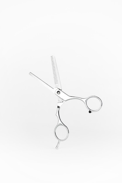 Открытые серебряные ножницы для стрижки волос на белом фоне Открытые парикмахерские ножницы на белом фоне