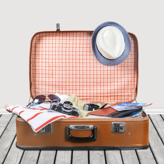 Photo open suitcase with hat and sunglasses