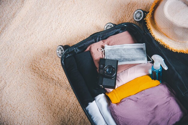 Open suitcase with traveler belongings clothes and accessories of things ready packing to be taken on summer holiday