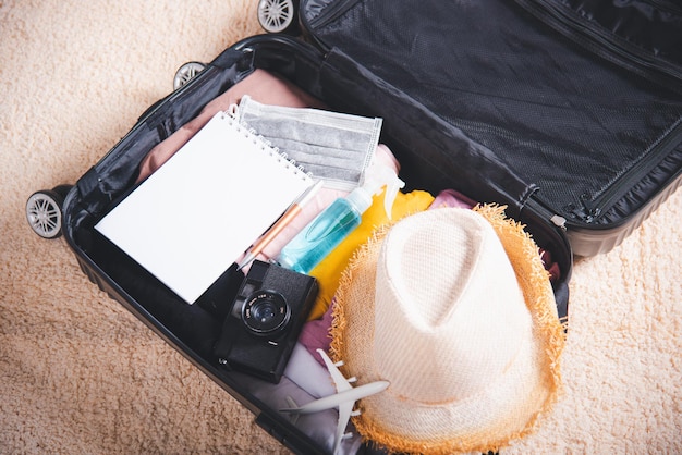 写真 旅行者の所持品の服や物の付属品を詰め込んだスーツケースを開ける
