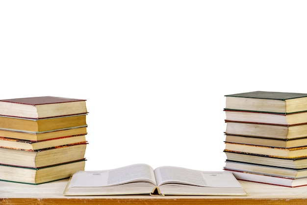 An open textbook and stacks of books on reading desk Learning concept Isolated on white background