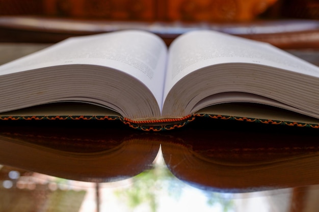 an open thick book divided in half on a wooden table