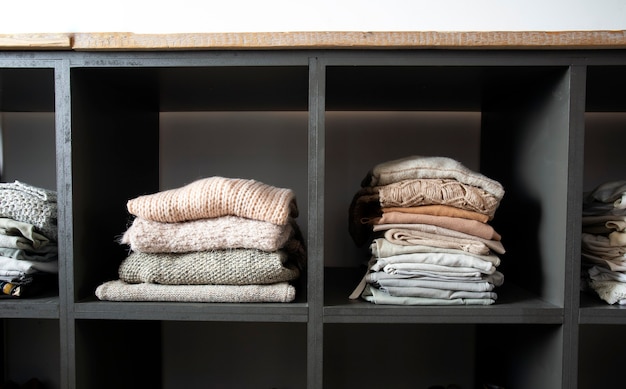 Фото Открытый шкаф с множеством сложенных вещей организованный шкаф с нагроможденной одеждой современно и чисто в ...