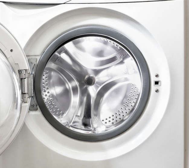 Open washing machine with empty white drum close-up