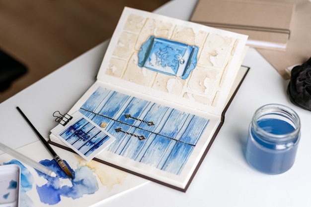 Photo an open watercolor sketchbook lies on a white table
