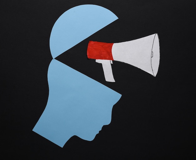 Open your mind mental health concept creative thinking Paper silhouette of human head and megaphone on black background