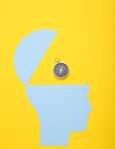 open your mind mental health concept creative thinking paper silhouette of human head with compass on yellow background