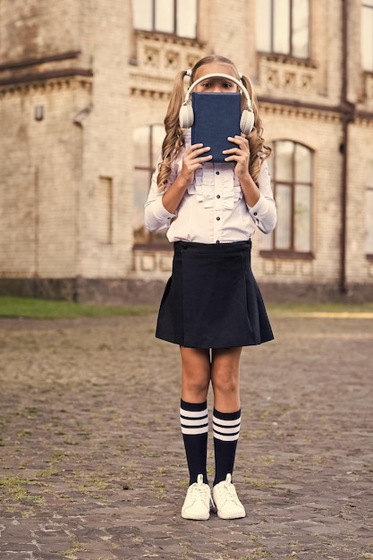 Open your world old school music back to school elearning vintage kid fashion small happy girl listen ebook using headset technology schoolgirl in classy retro uniform listen audio book