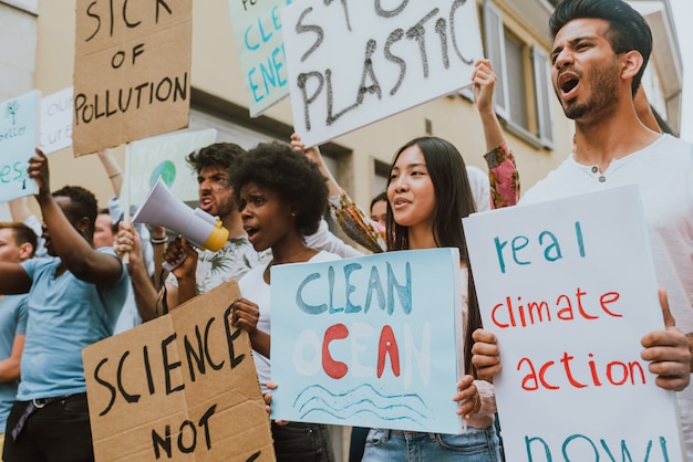 Openbare demonstratie op straat tegen de opwarming van de aarde en vervuiling. Groep multi-etnische mensen die protesteren tegen klimaatverandering en plastic problemen in de oceanen