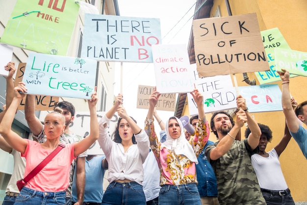 Openbare demonstratie op straat tegen de opwarming van de aarde en vervuiling. Groep multi-etnische mensen die protesteren tegen klimaatverandering en plastic problemen in de oceanen