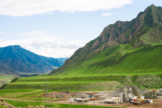 Opencast mining and quarrying in mountains. Heavy industry in highlands. Machinery at work.