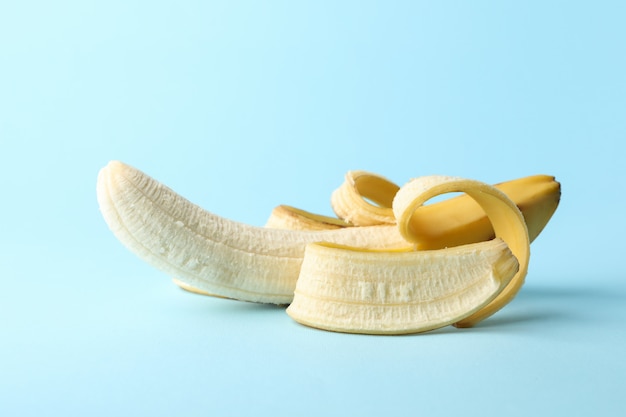 Opened banana on blue table. Fresh fruit