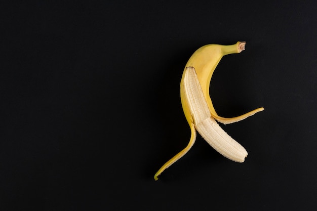 Открытый банан, открытая кожура фрукта, изолированная красочная поверхность, простое сырое питание