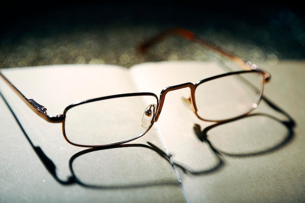 Opened book and eyeglasses on it close up