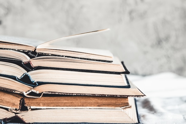 Opened books in a stack on a light home background. Education, hobbies