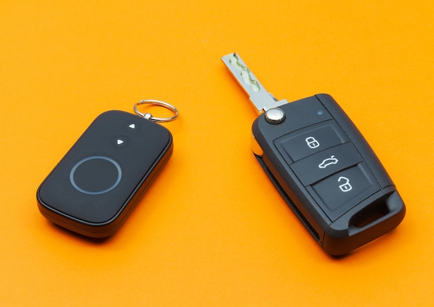 Opened car key with remote control on an orange background