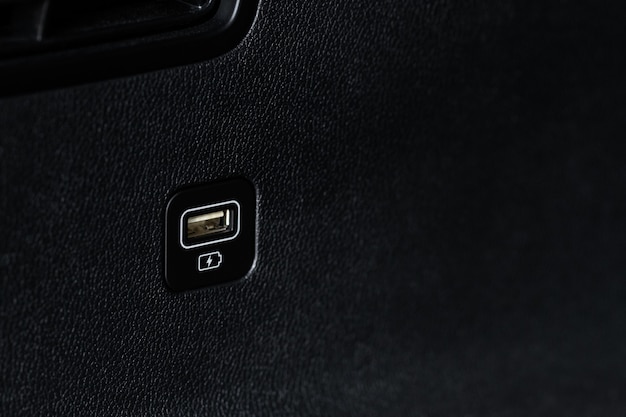 Opened car USB port in the car for connecting device. Power output of usb charger close up view. Car interior.