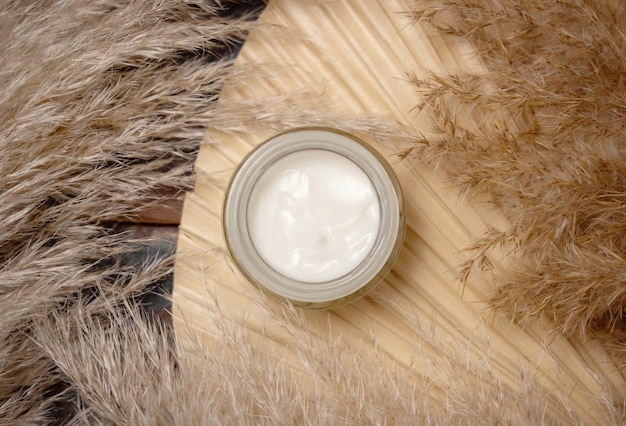 Opened cream jar on dried palm leaf near pampas grass Cosmetic Mockup