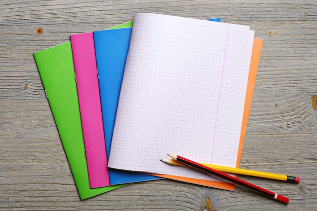 Photo opened exercise books and pencils on the desk