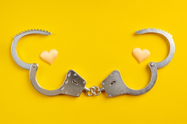 Photo opened handcuffs on yellow background. release from prison, freedom concept. imprisonment, deprivation of liberty and apprehend perpetrators.