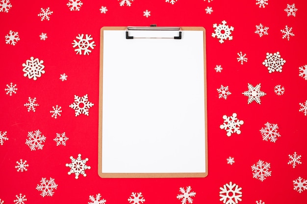 Opened notebook and Holiday decorations on red background. flat lay style. Christmas planning concept.