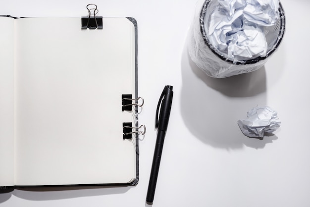 Opened notebook on a white background with crumpled papers